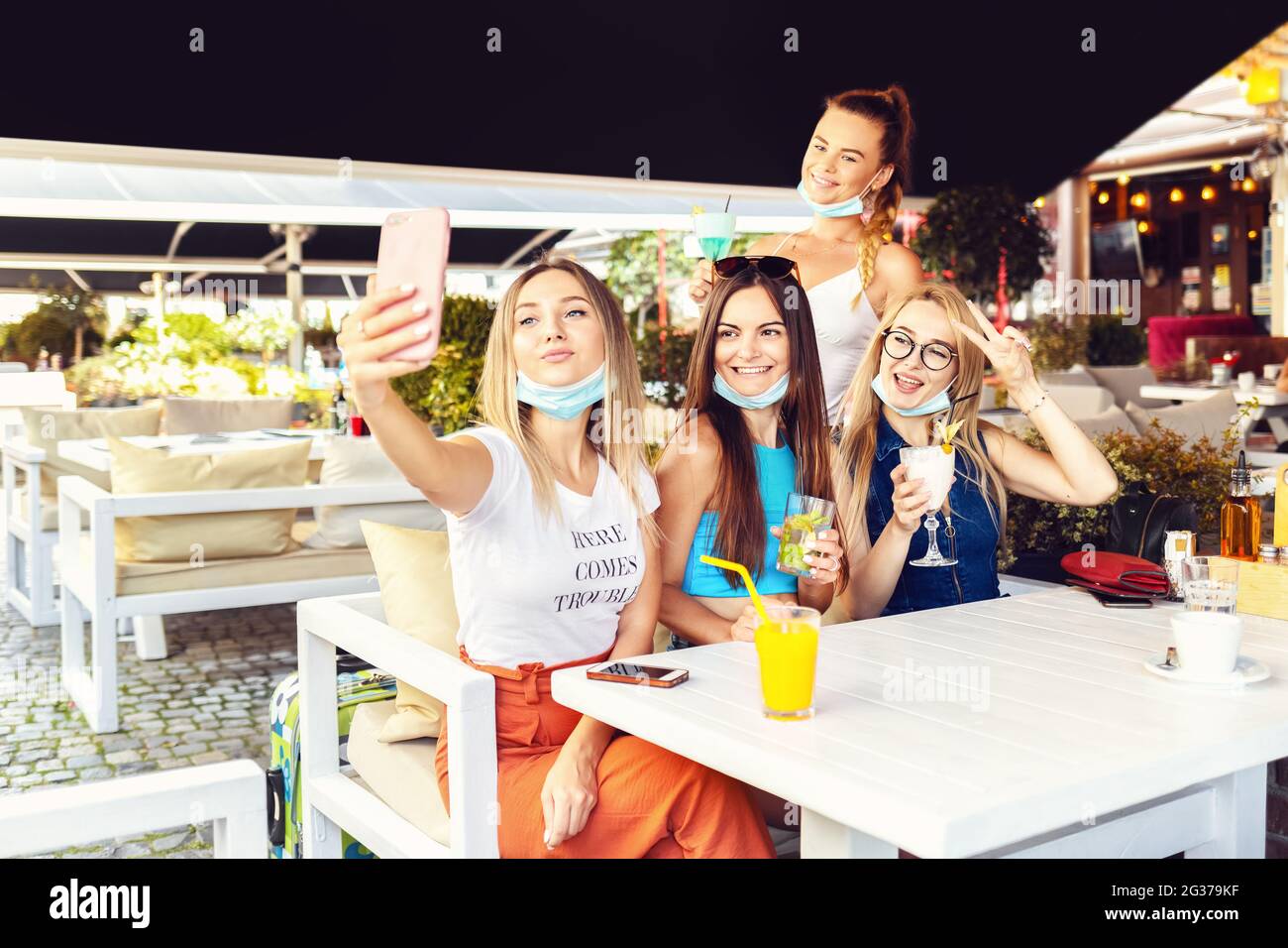 Felice vaccinato giovani amici ragazza che prendono selfie al cocktail party al ristorante alla moda pub Foto Stock