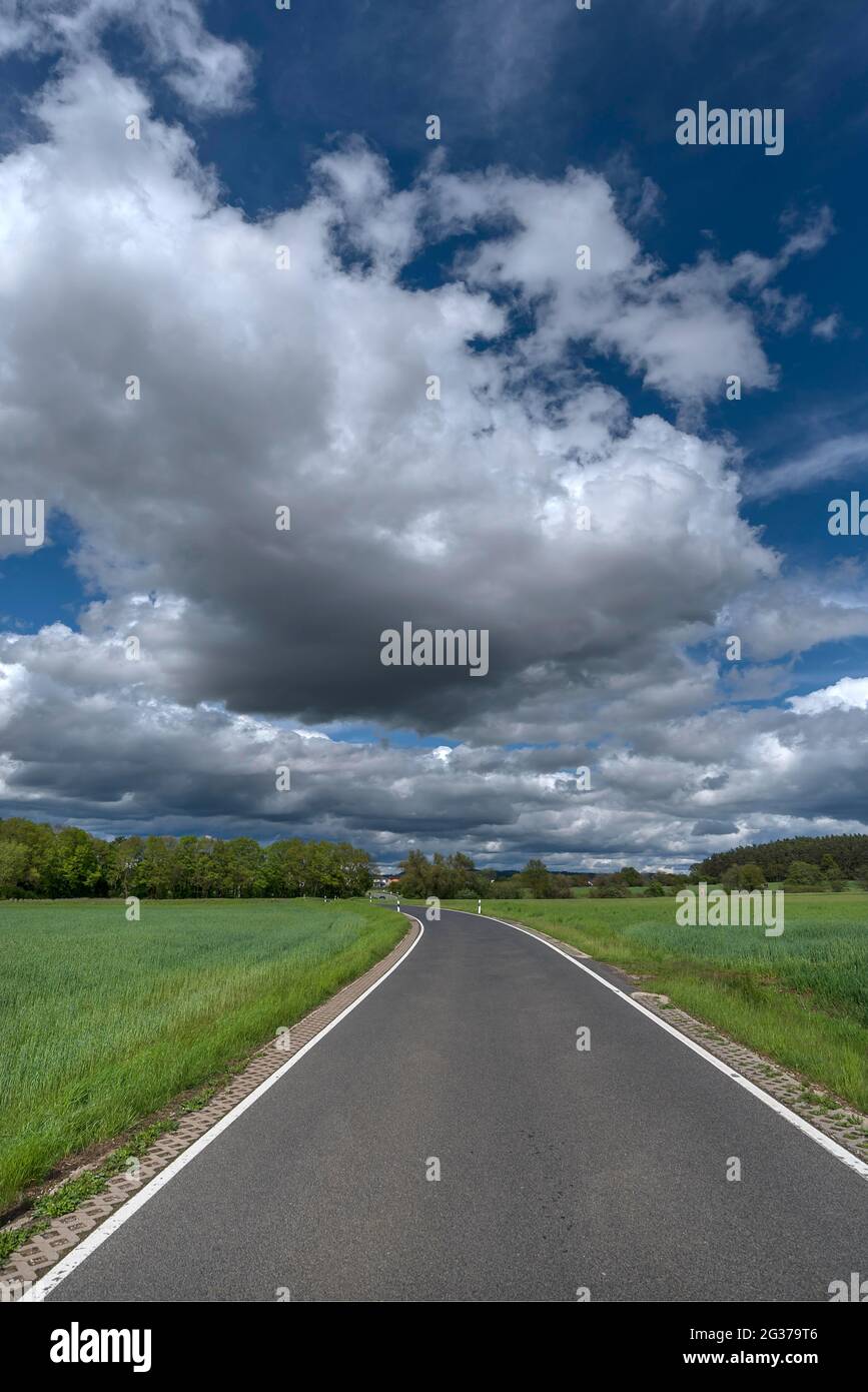 Paesaggio con strada e cielo nuvoloso, Baviera, Germania Foto Stock