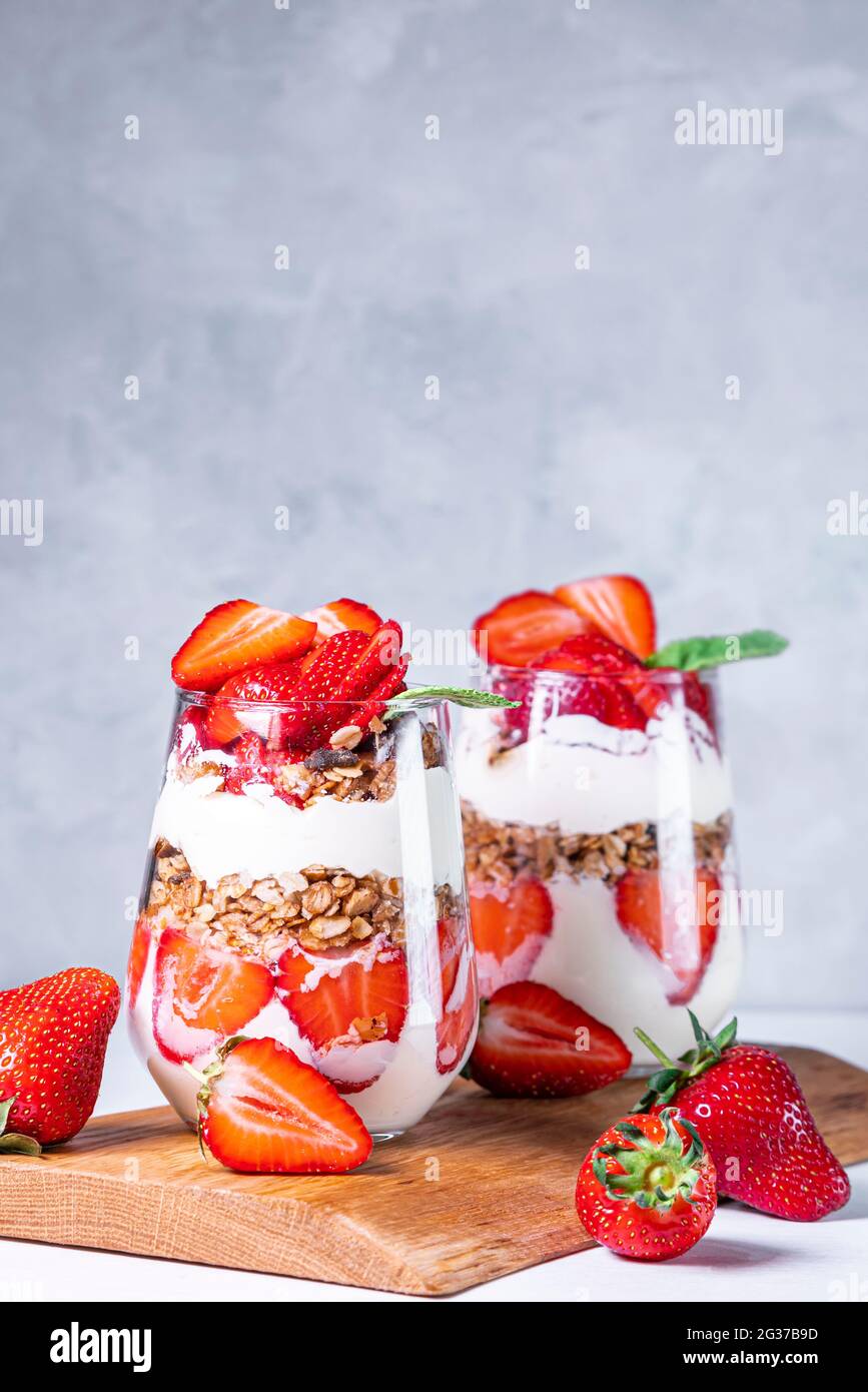 Colazione salutare con fragole preparate con fragole fresche, yogurt e muesli in bicchieri. Foto Stock