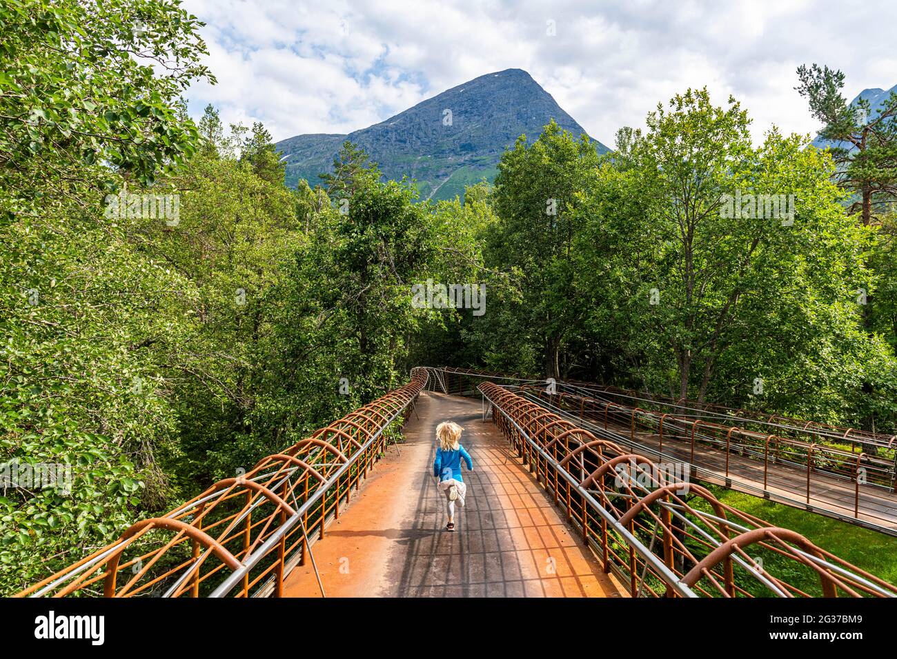 Ragazza che cammina su un ponte d'acciaio molto moderno, Gudbrandsjuvet, Trollstigen strada di montagna, Norvegia Foto Stock