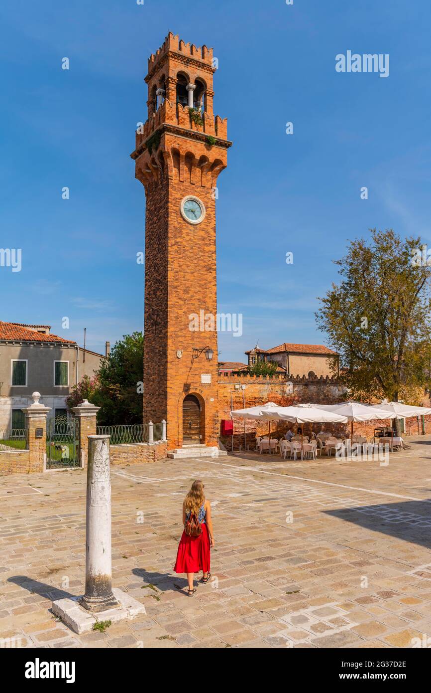 Tourist in abito rosso di fronte al campanile di San Stefano, Murano, Venezia, Veneto, Italia Foto Stock