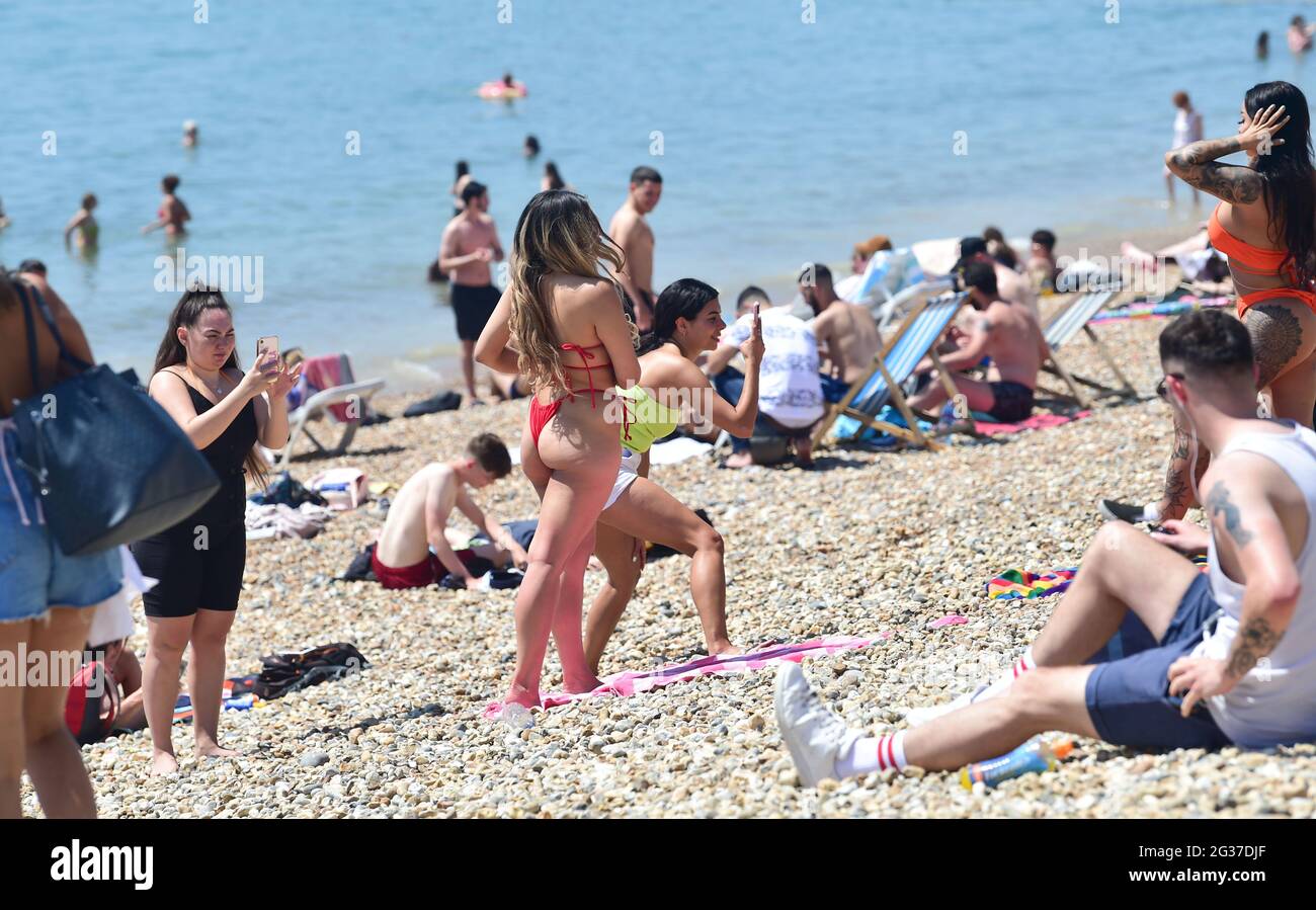 Brighton UK 14 giugno 2021 - tempo di posa per alcune fotografie come la folla godere del sole caldo sulla spiaggia di Brighton oggi come le temperature sono previste per raggiungere l'alto centigradi 20 nel Sud-est ancora : Credit Simon Dack / Alamy Live News Foto Stock