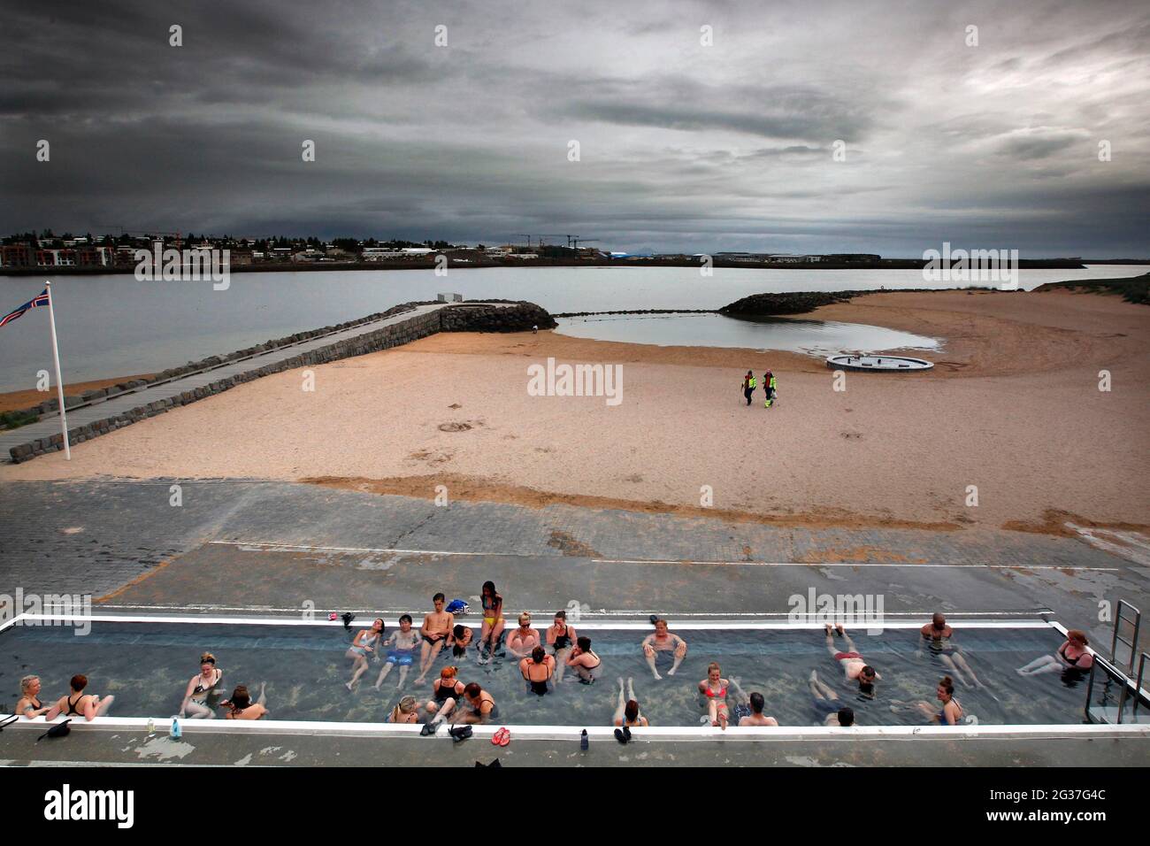 Piscina di acqua calda, piscina sulla spiaggia, bagnanti, Nautholsvik, Reykjavik, Islanda Foto Stock