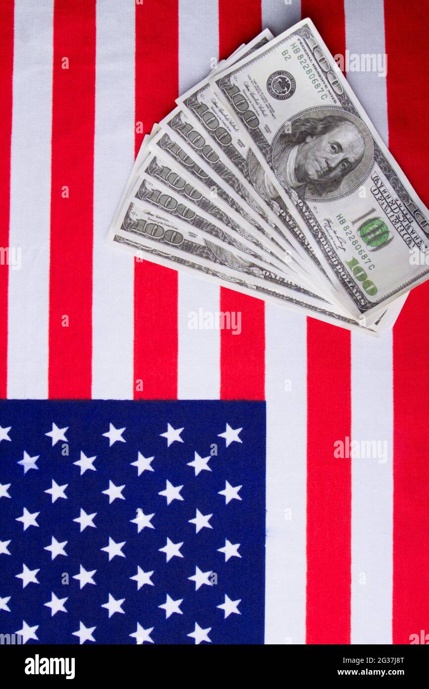 Colpo verticale della bandiera degli stati uniti e delle banconote in dollari. Foto Stock