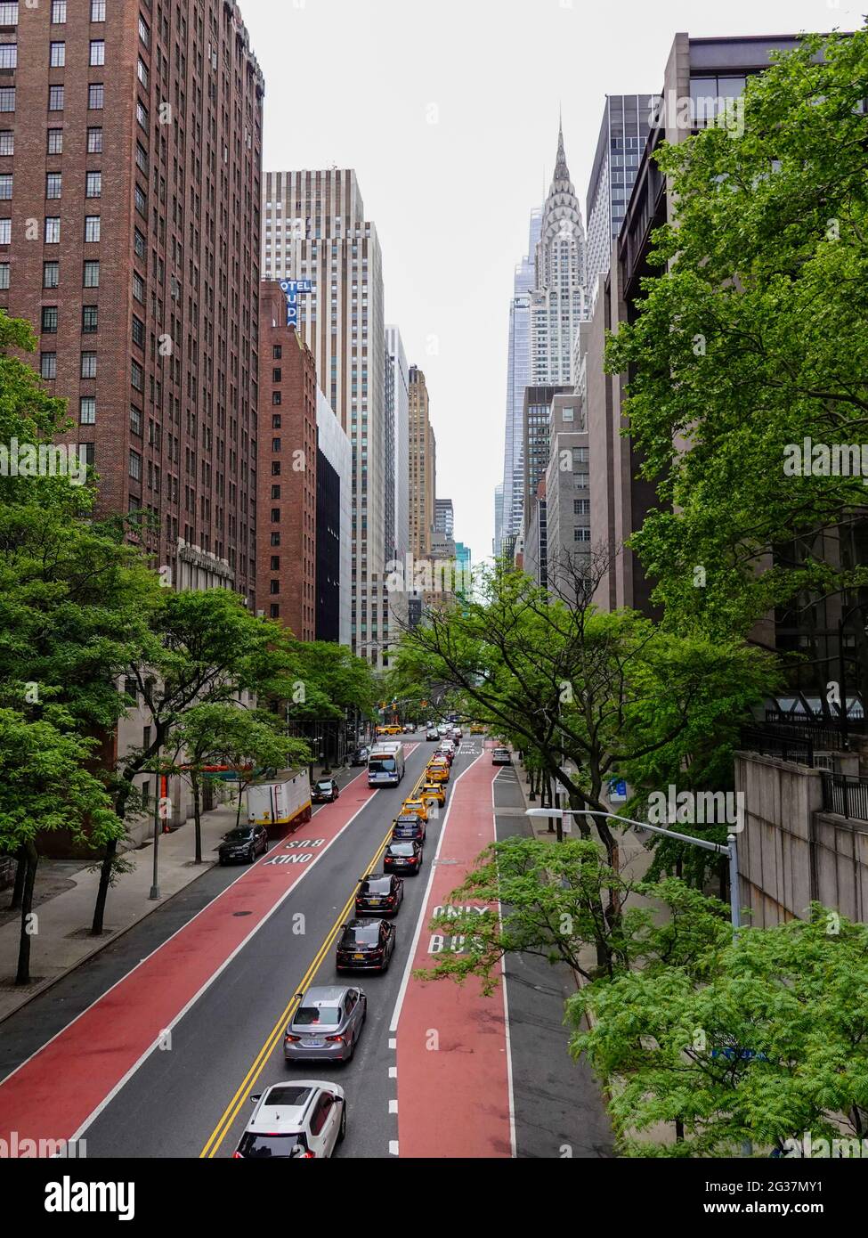 Traffico di Midtown dirigendosi ad ovest sulla 42nd strada Est, New York, NY, USA con vista dei grattacieli in lontananza. Foto Stock