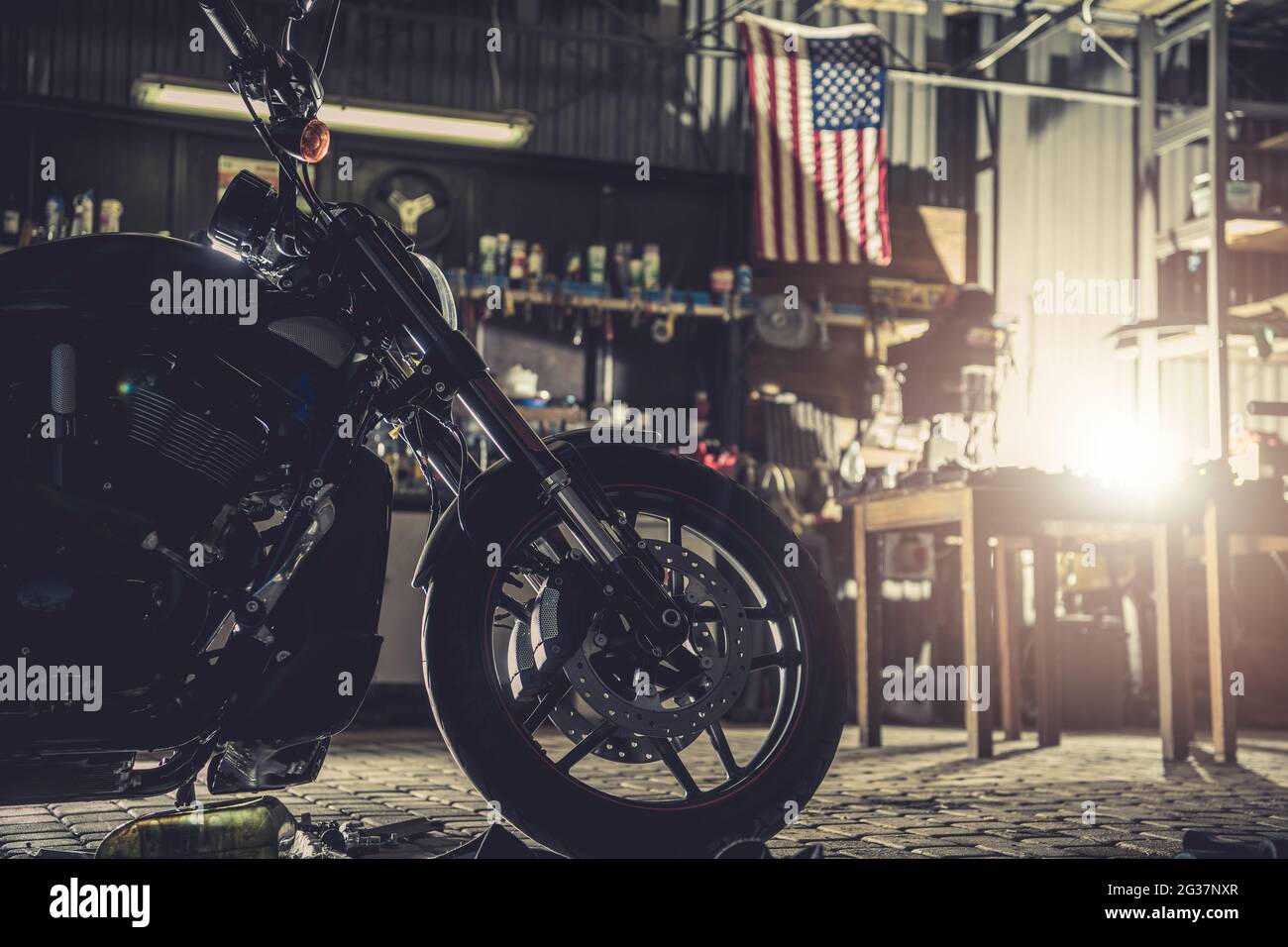 Moto moderna in garage. Strumenti e bandiera americana in background. Tema bicicletta da corsa. Foto Stock