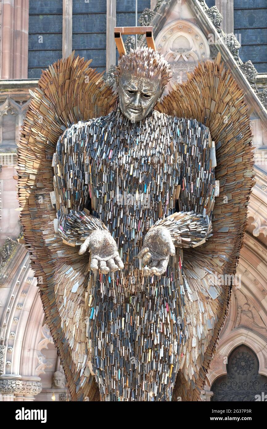 Hereford, Herefordshire, Regno Unito - Lunedi 14 giugno 2021 - la statua dell'angelo del coltello in alto fuori della cattedrale sostenuta da una cornice - la statua di 3.5 tonnellate di altezza 27 piedi è fatta di 100,000 coltelli confiscati ed è stata creata dallo scultore Alfie Bradley. La statua dell'Angelo dei coltelli aumenta la consapevolezza dell'impatto del crimine dei coltelli e sarà esposta all'esterno della cattedrale di Hereford fino al 12 luglio 2021. Photo Steven May / Alamy Live News Foto Stock