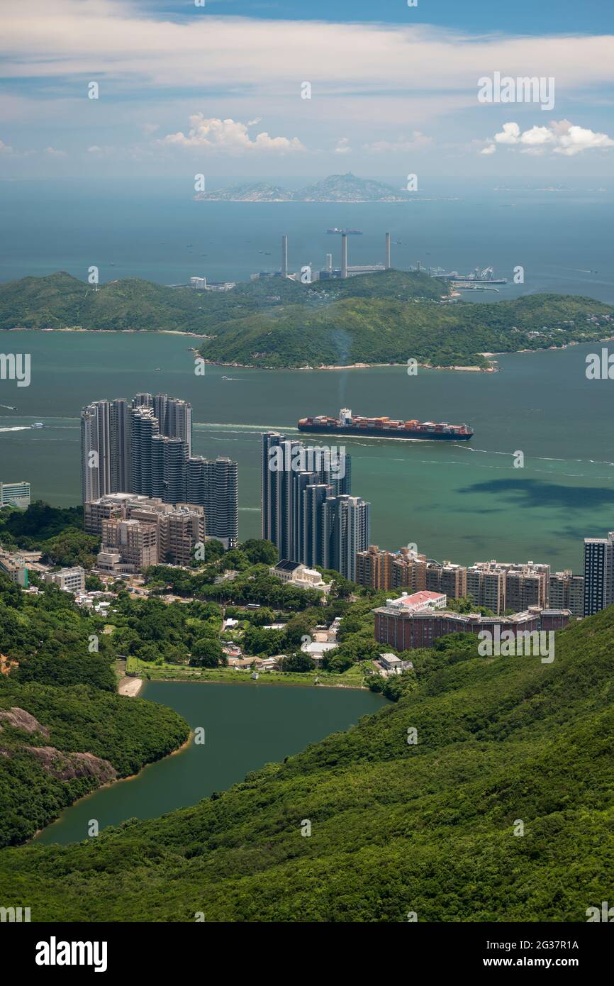 Una nave nel canale di Lamma Est passa davanti alle alte e lussuose torri residenziali del Residence Bel-air a Pok fu Lam sull'Isola di Hong Kong Foto Stock