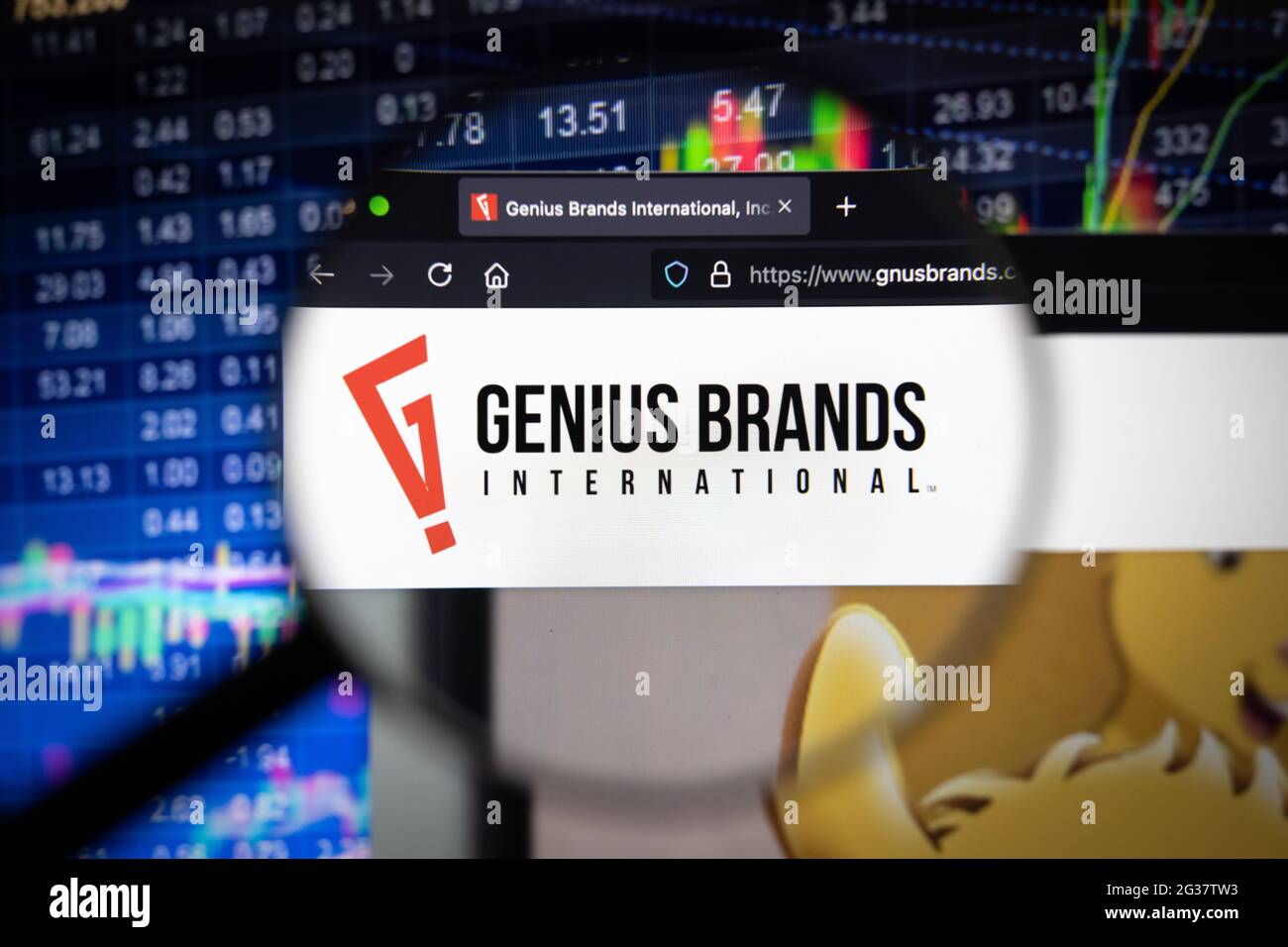 Logo aziendale di Genius Brands su un sito Web con sviluppi sfocati del mercato azionario sullo sfondo, visto sullo schermo di un computer attraverso una lente di ingrandimento Foto Stock