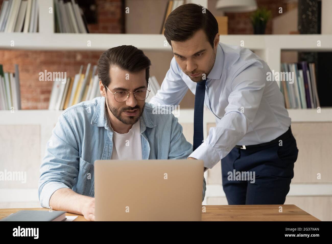 Sicuro capo maschio esperto istruire il nuovo lavoratore. Foto Stock
