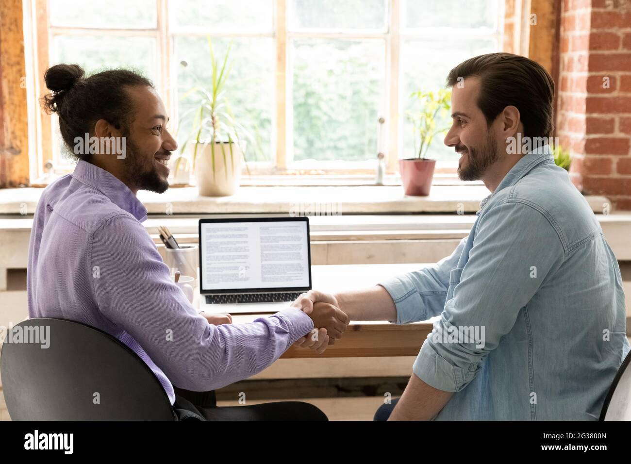 Due uomini d'affari di razza misti che stabiliscono una partnership. Foto Stock