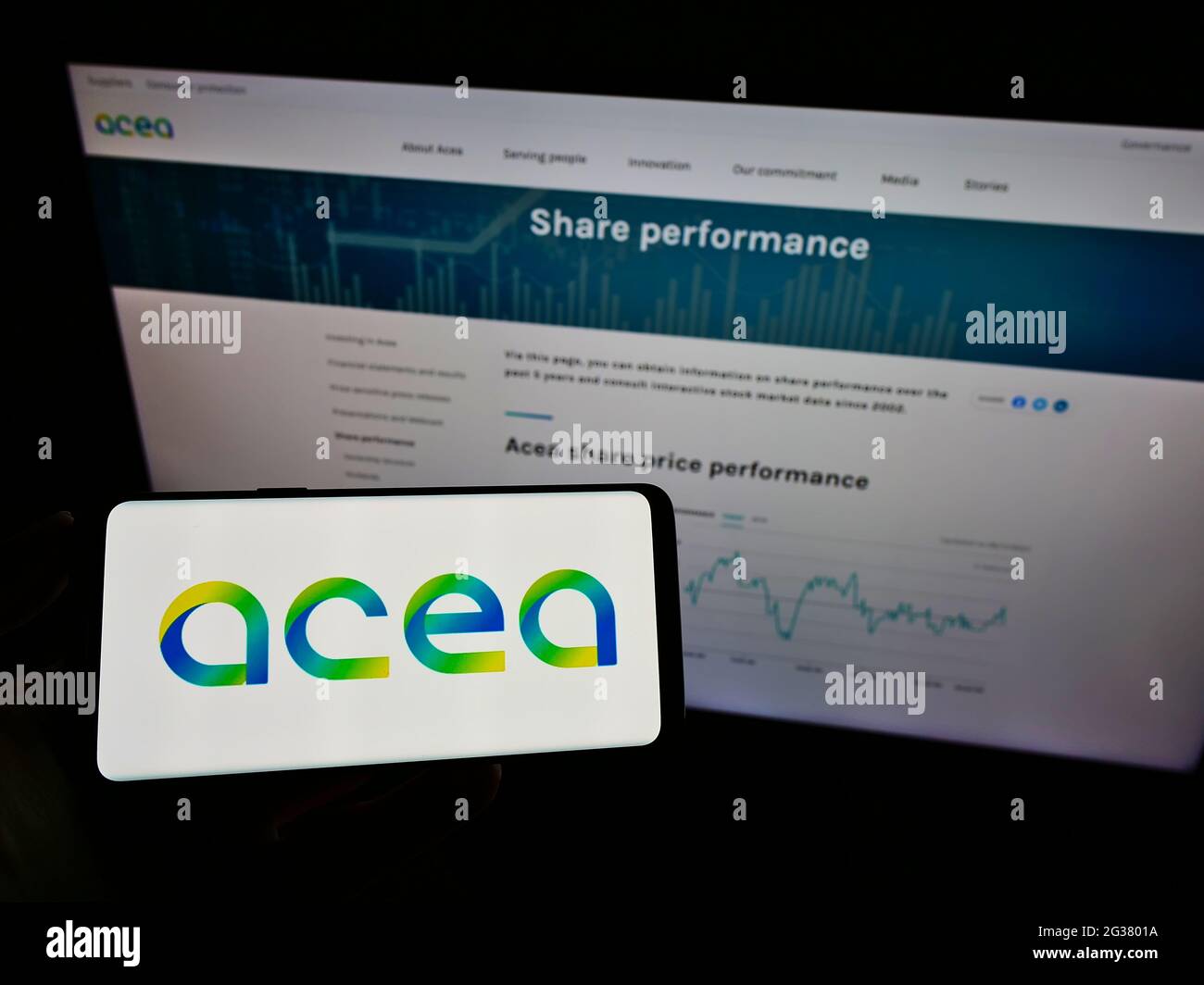 Persona titolare smartphone con logo della società di servizi italiana ACEA S.p.A. sullo schermo davanti al sito web. Mettere a fuoco il display del telefono. Foto Stock