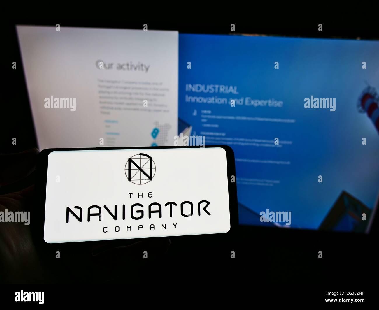 Persona titolare cellulare con logo della società di carta portoghese The Navigator Company SA sullo schermo di fronte alla pagina web. Mettere a fuoco il display del telefono. Foto Stock