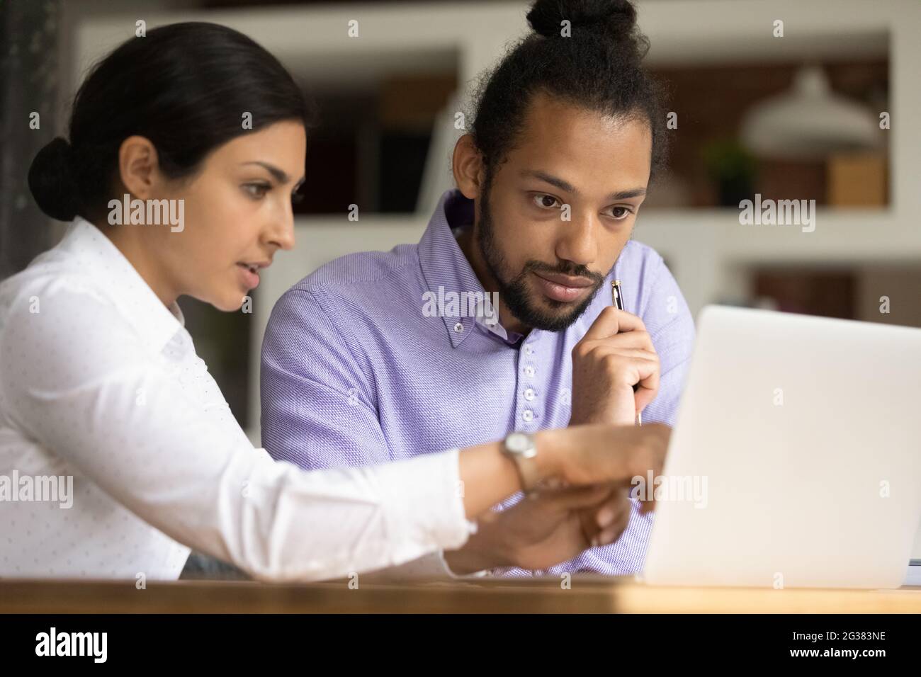 Ha concentrato due dipendenti di corse miste che lavorano al computer. Foto Stock