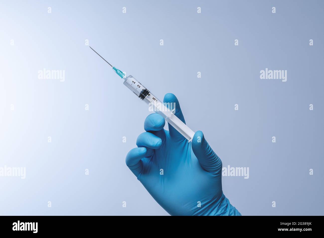 Medico in guanti di lattice blu con siringa. Vaccinazione, immunizzazione, trattamento per infezione da virus Corona Covid 19. Concetto sanitario e medico. Foto Stock