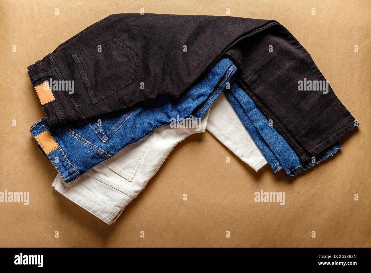 Pantaloni Black White Blue jeans. Assortimento di diversi colori denim abbigliamento in negozio con etichetta emty. Pantaloni bianchi in denim jean, jeans blu, neri Foto Stock