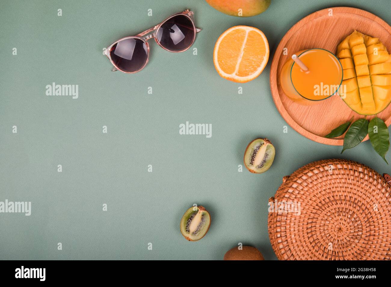 Composizione estiva. Occhiali da sole mango, arancio, kiwi su sfondo verde.  Disposizione piatta Foto stock - Alamy