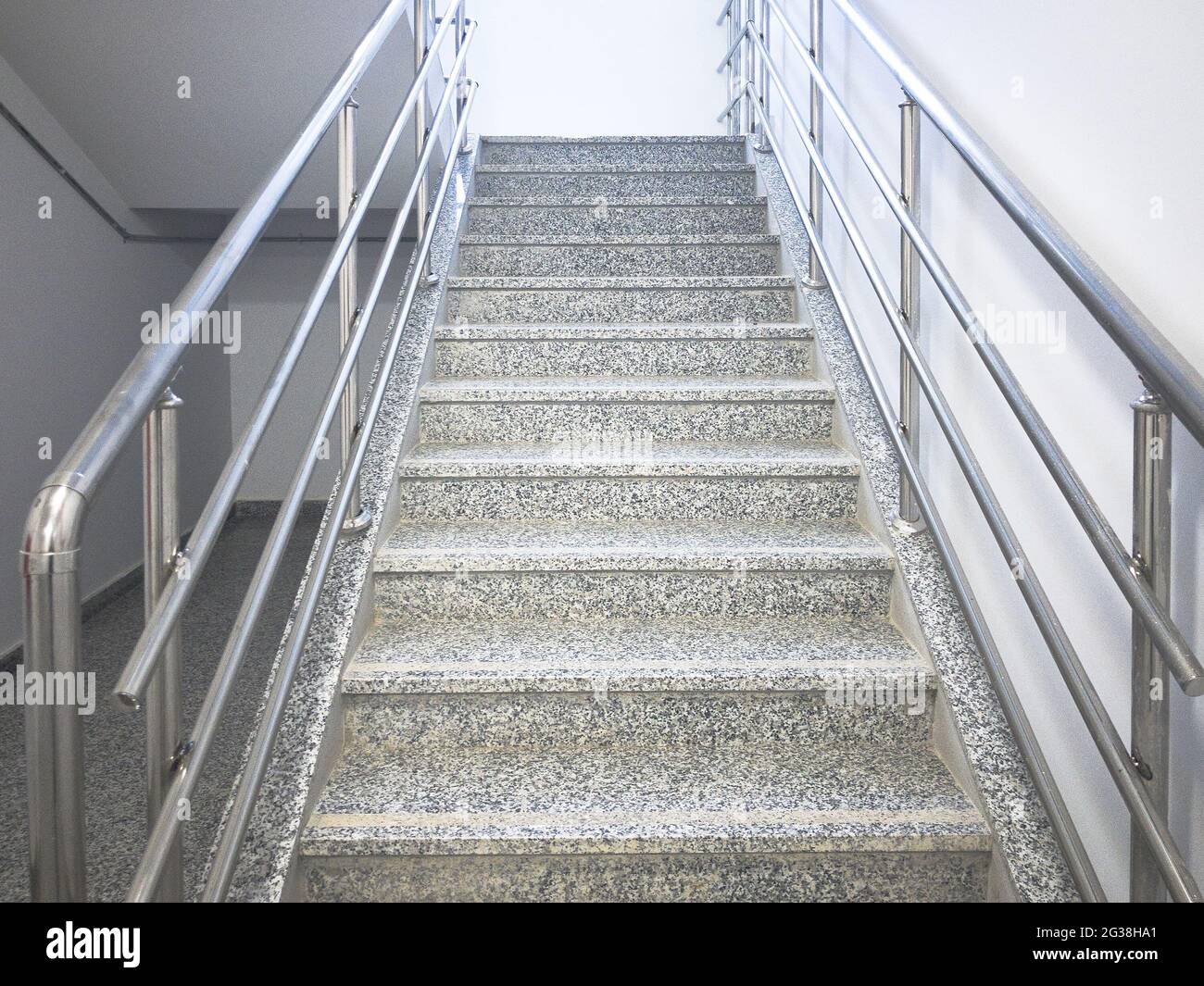 Scala vuota con corrimano cromati in un edificio industriale prefabbricato Foto Stock