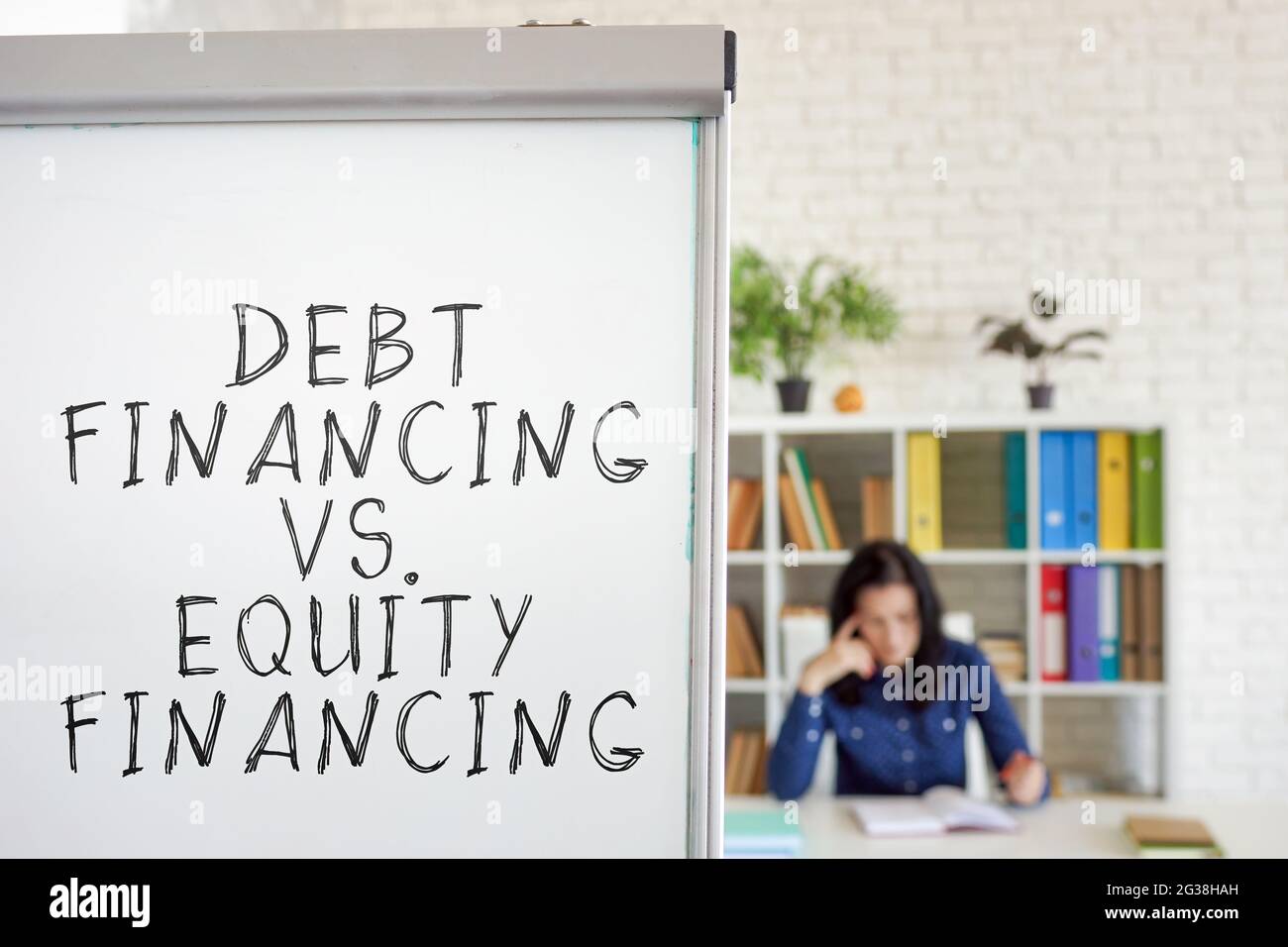 Finanziamento del debito vs finanziamenti azionari parole sulla lavagna. Foto Stock