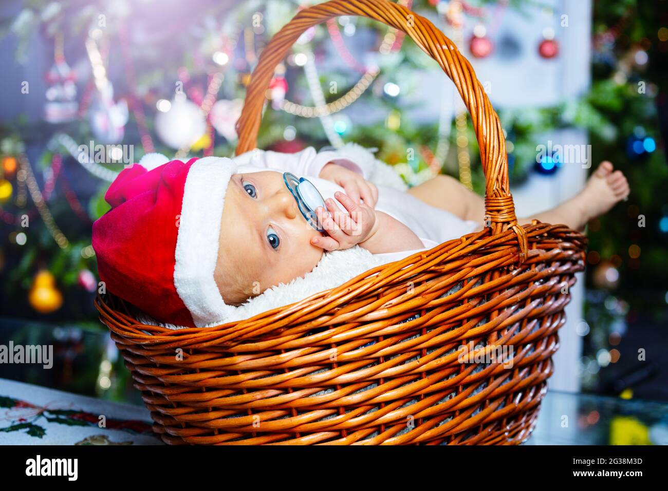 Neonato nel cestino sotto l'albero di Natale Foto stock - Alamy