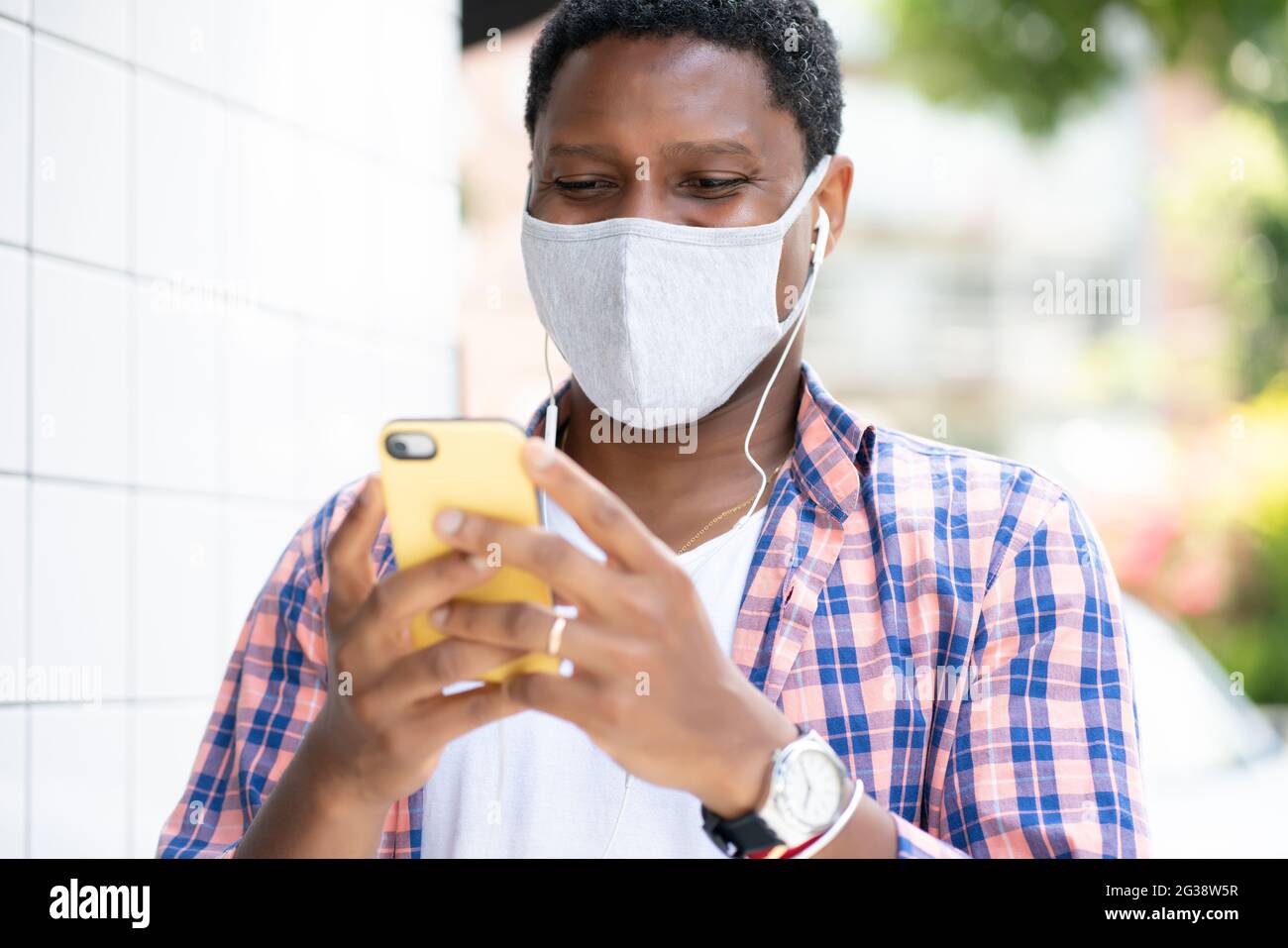 Uomo che usa il suo telefono per strada. Foto Stock