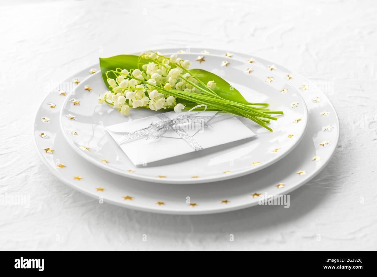 Bella tavola con fiori giglio-della-valle su sfondo chiaro Foto Stock