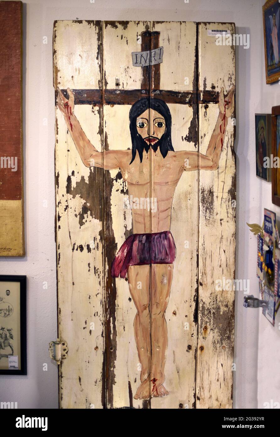 Un dipinto amatoriale di Gesù Cristo sulla Croce dipinto su una porta fienile in vendita in un negozio di antiquariato a Santa Fe, New Mexico. Foto Stock