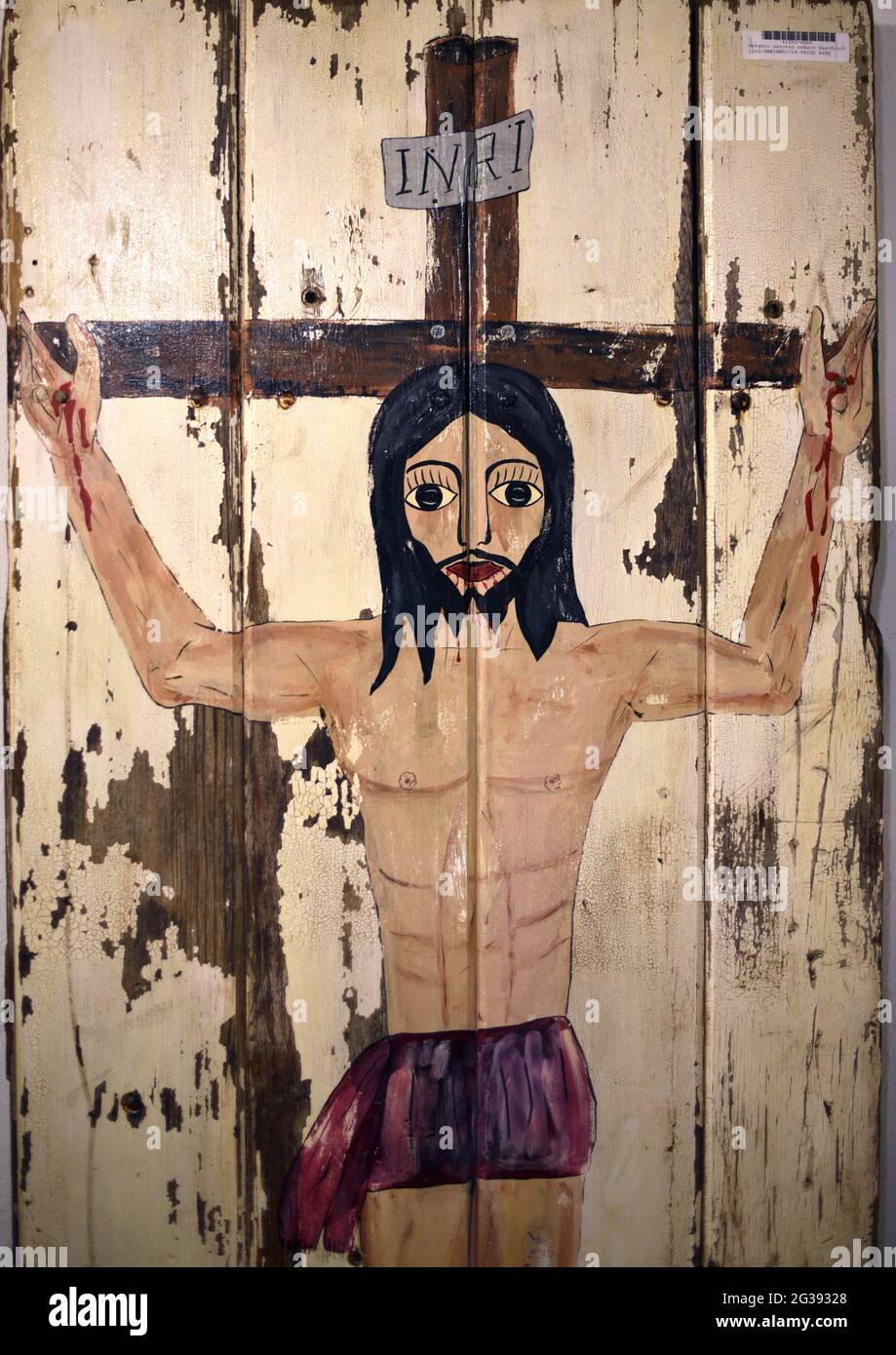 Un dipinto amatoriale di Gesù Cristo sulla Croce dipinto su una porta fienile in vendita in un negozio di antiquariato a Santa Fe, New Mexico. Foto Stock