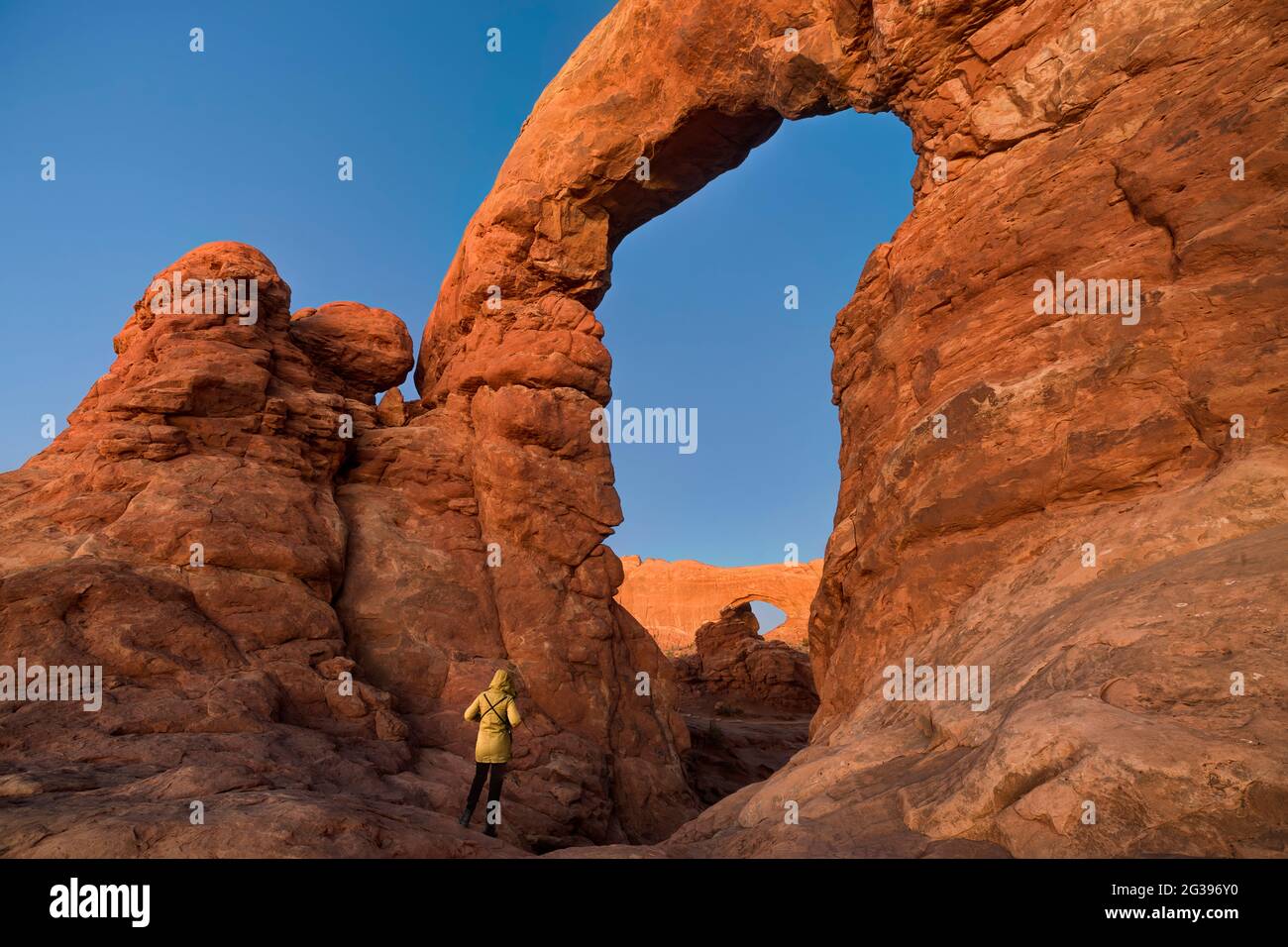 Donna che guarda Turret Arch dopo il tramonto, Arches National Park, Utah, USA Foto Stock
