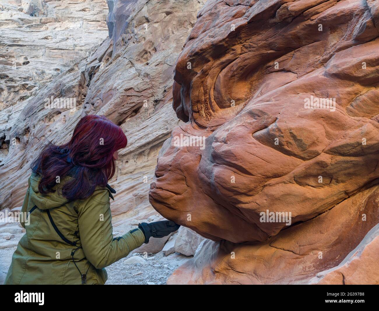 Donna che tocca la formazione rocciosa, Little Wild Horse Canyon, Utah, USA Foto Stock