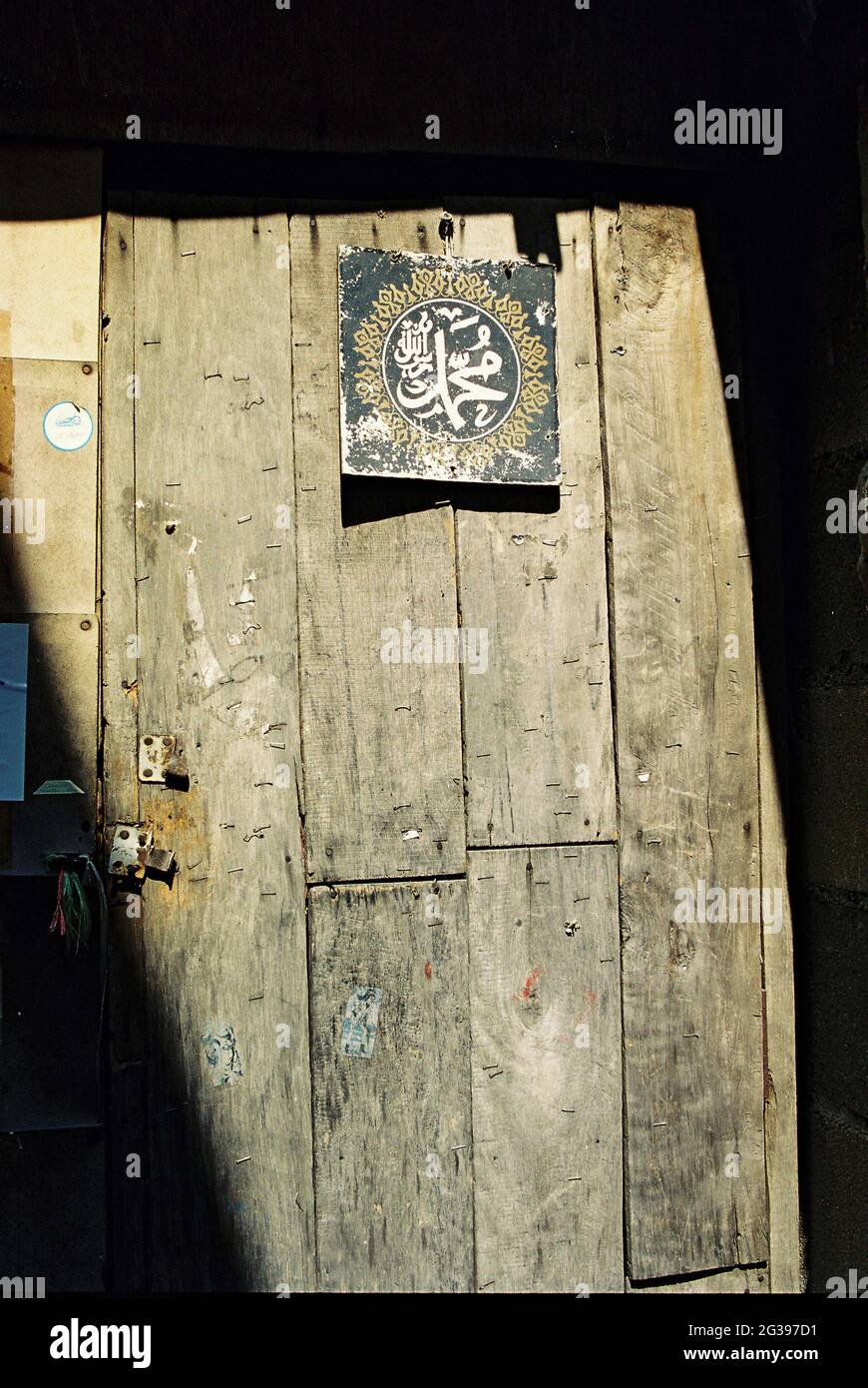 Calligrafia araba recante la parola "Mohammed" pubblicata sulla porta posteriore dell'antico cimitero della Moschea della Comunità di Baan-Krua. Ricorda a tutti i musulmani il profeta e di essere fedeli nella loro religione fino al giorno della loro morte. Bangkok, Thailandia. Foto Stock