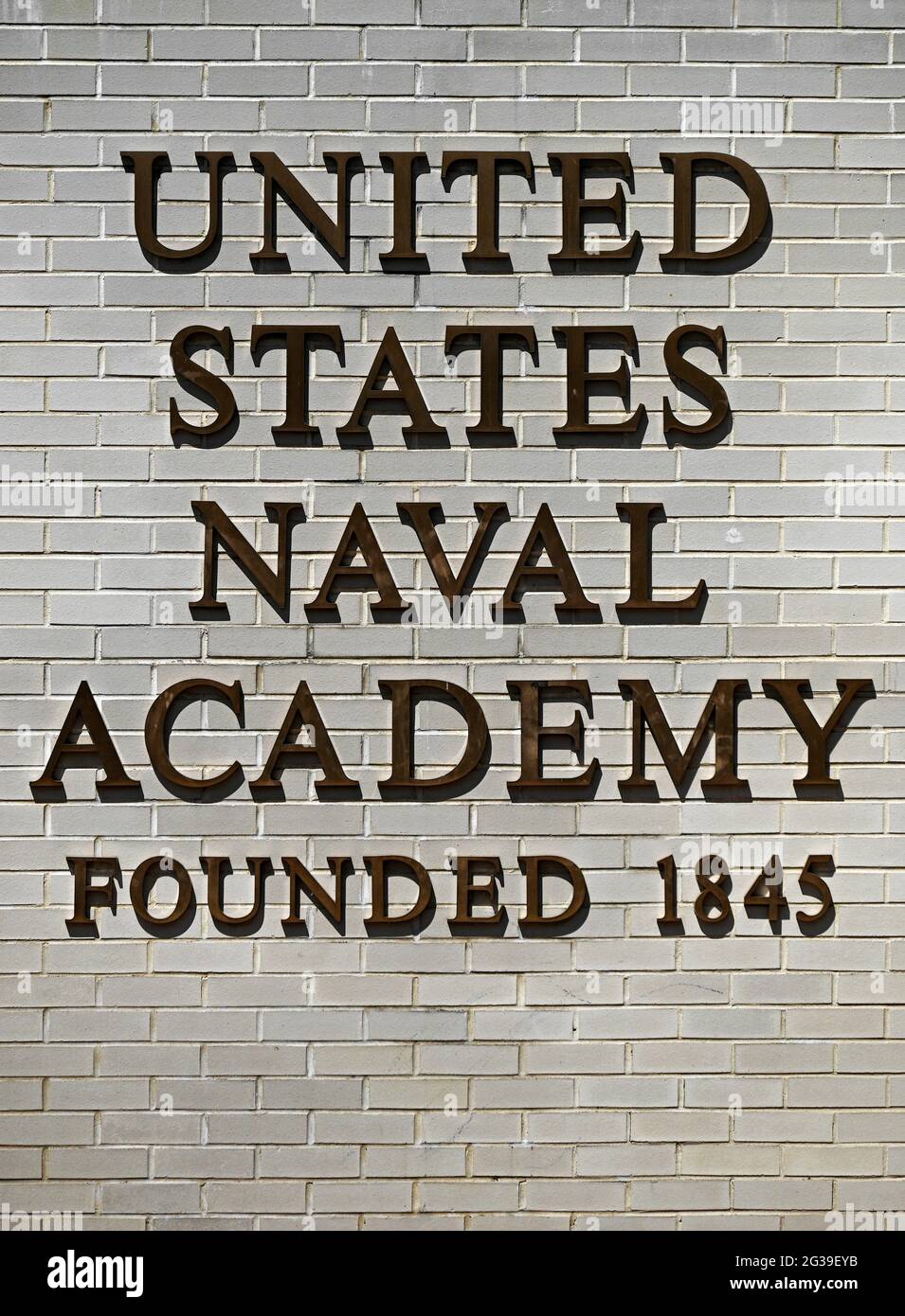 Cartello d'ingresso alla U.S. Naval Academy con scritte in grassetto su mattoni bianchi ad Annapolis, Maryland. Foto Stock