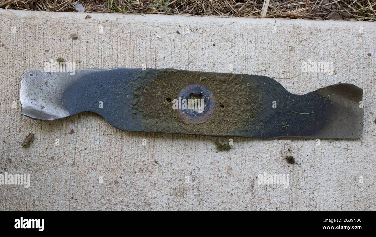 Un primo piano di una lama del tosaerba usurata Foto Stock Un primo piano di una lama del tosaerba usurata Foto Stock
