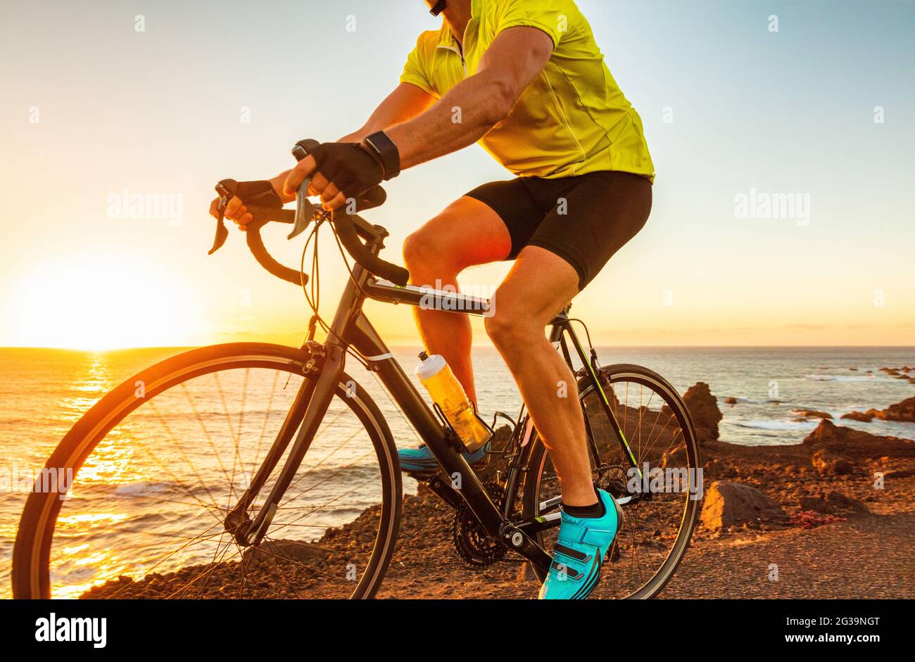 Bicicletta ciclista equitazione bici da strada con atleta smartwatch allenamento al tramonto in bicicletta all'aperto. Sport orologio fitness intelligente Foto Stock