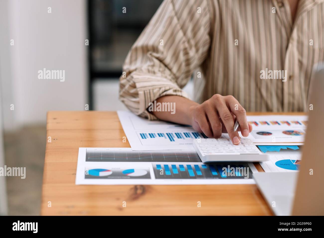 Primo piano concetto di contabilità aziendale, uomo d'affari che utilizza la calcolatrice con computer portatile, budget e carta di prestito in ufficio Foto Stock