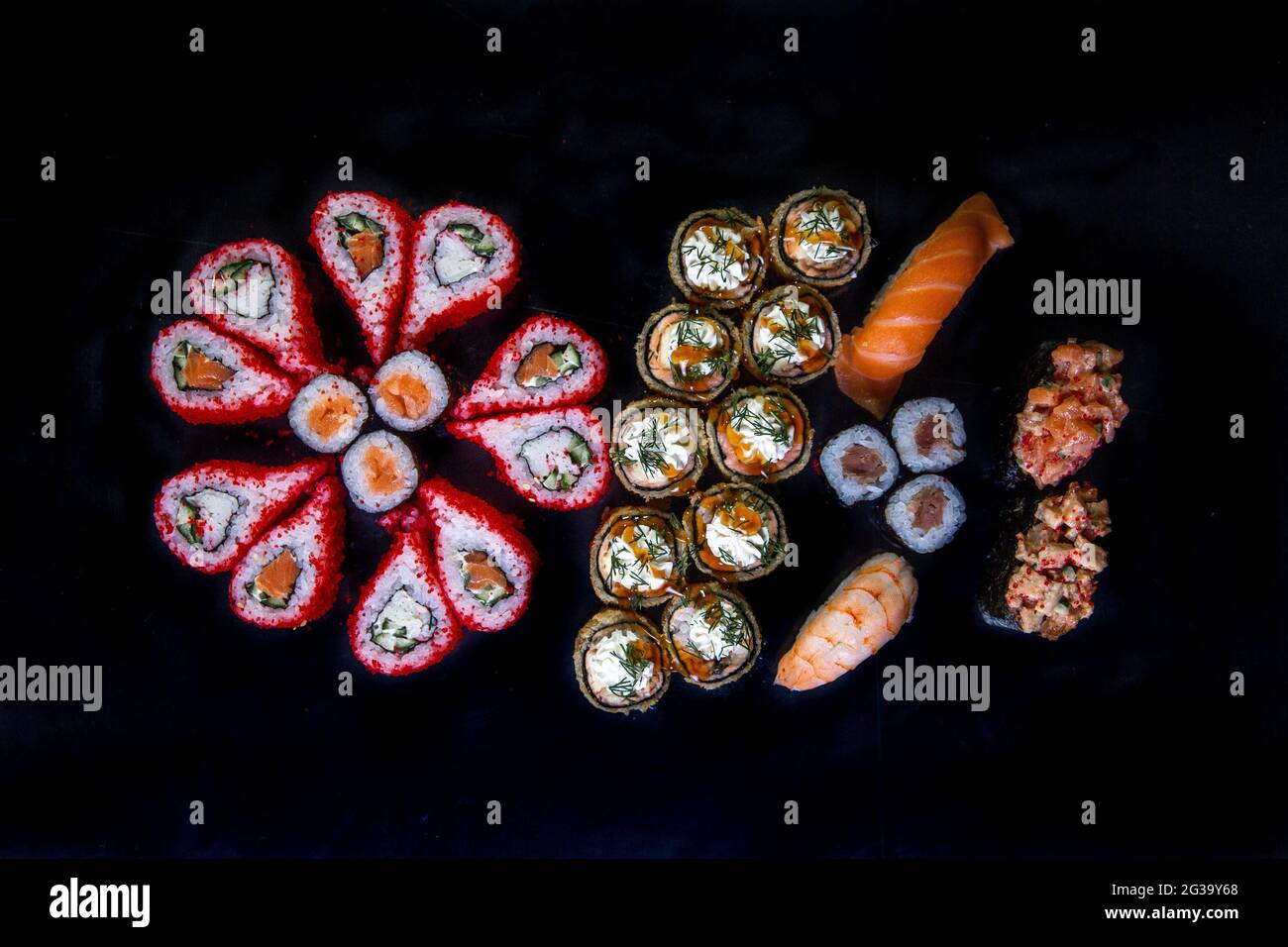 grande set di sushi e panini cucina giapponese vista dall'alto su sfondo nero. Foto Stock