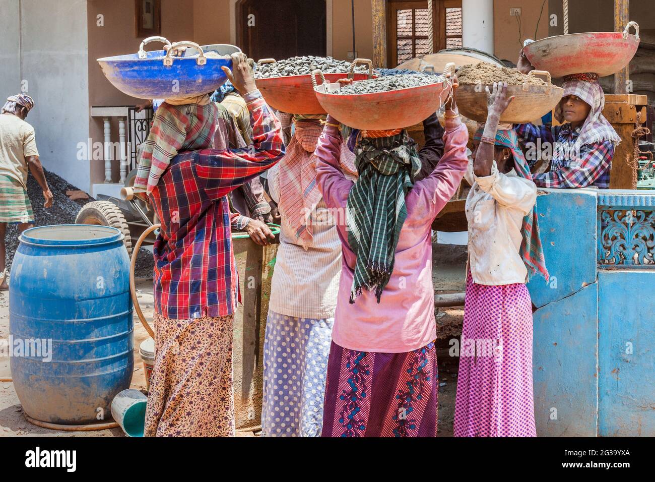 Lavoratrici indiane manuali che trasportano carichi pesanti sulle loro teste in cantiere, Agonda, Goa, India Foto Stock