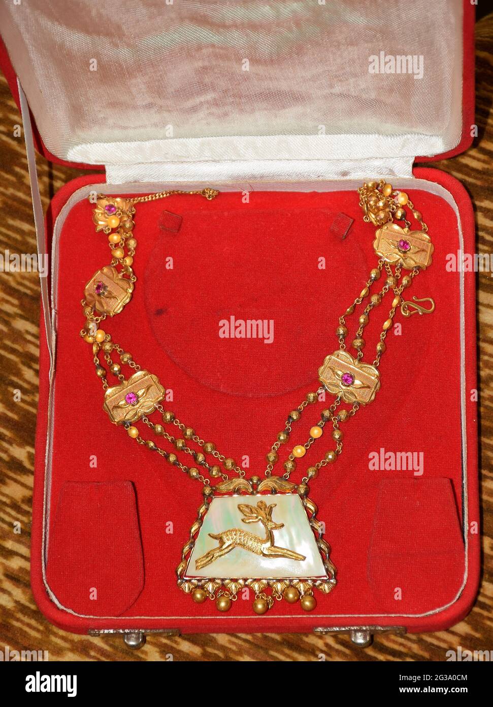 Collana indiana tradizionale in oro conservata in una scatola di gioielli di colore rosso Foto Stock
