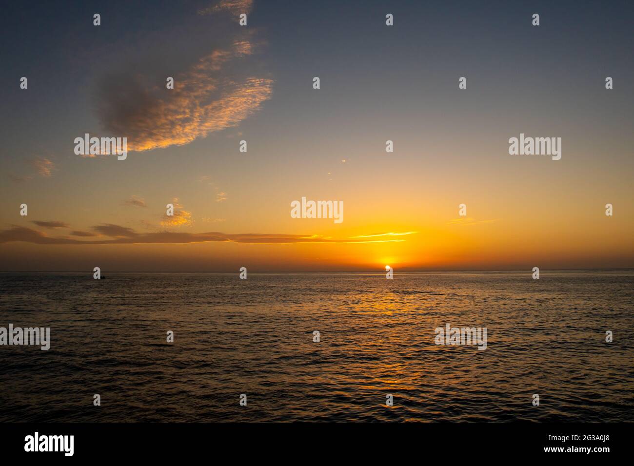 Tramonto arancione e viola sul Mar Rosso e sulle montagne sudanesi all'orizzonte, serata tranquilla, vista da una nave, con le nuvole di circo sul cielo. Foto Stock