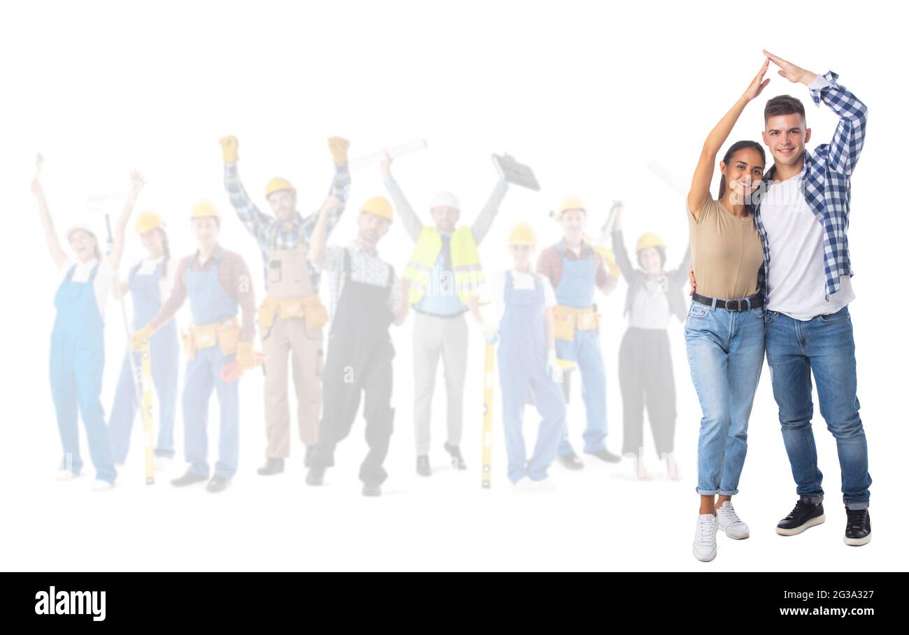 Felice giovane coppia che tiene la mano sopra la testa mostrando il cartello casa tetto e felice operai edili su sfondo isolato su sfondo bianco Foto Stock