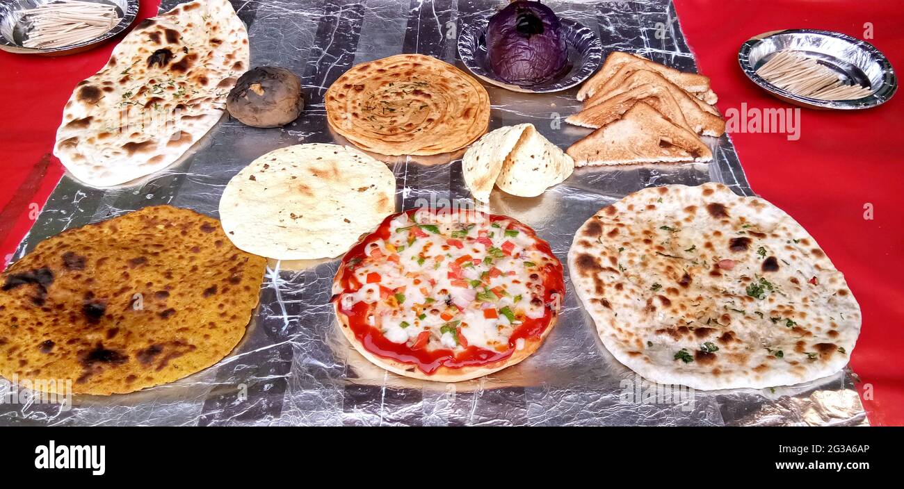 Varietà di chapati cotti, prantha, pizza e altri piatti in mostra presso il ristorante indiano Foto Stock
