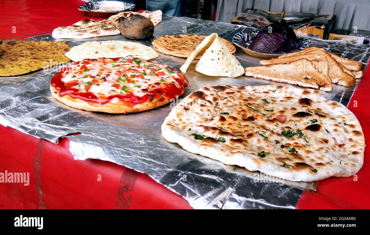 Varietà di chapati cotti, prantha, pizza e altri piatti in mostra presso il ristorante indiano Foto Stock