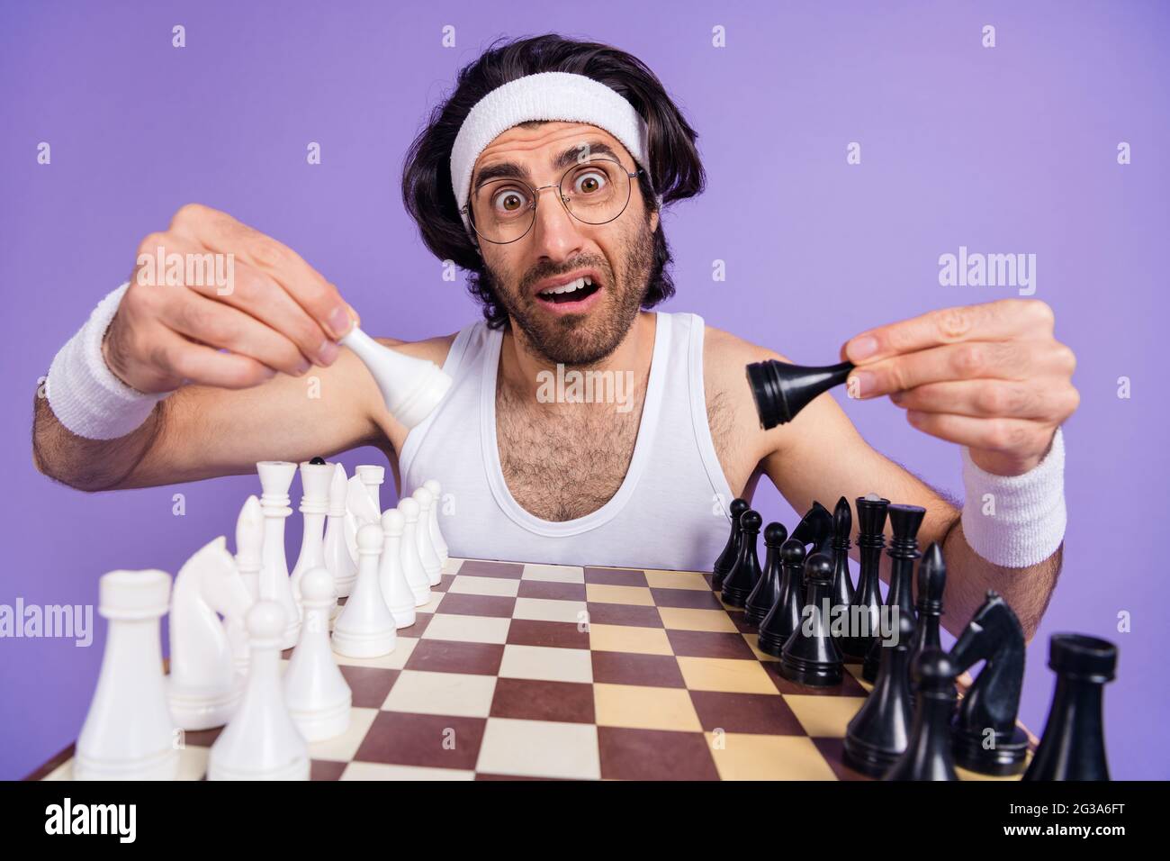 Foto di un ragazzo incerto gioco di scacchi indossare occhiali bianco singlet fairband isolato su sfondo lilla colore Foto Stock