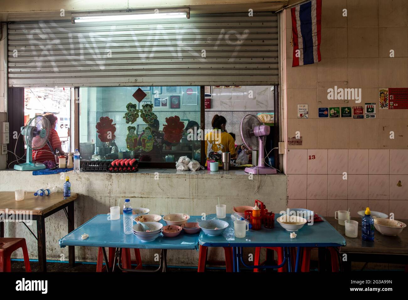 Un tavolo disordinato è lasciato dai commensali pieni e felici in questo Bangkok, Thailandia, ristorante che si specializza in congee, un piatto di cereali caldi. Foto Stock