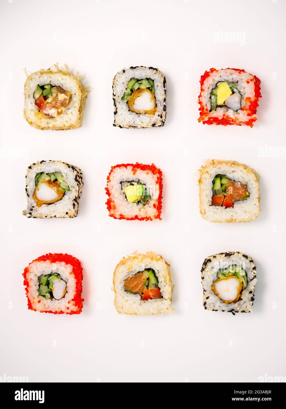 vari sushi su sfondo bianco, vista dall'alto. sushi maki con frutti di mare, salmone, gamberi, avocado e cetriolo Foto Stock