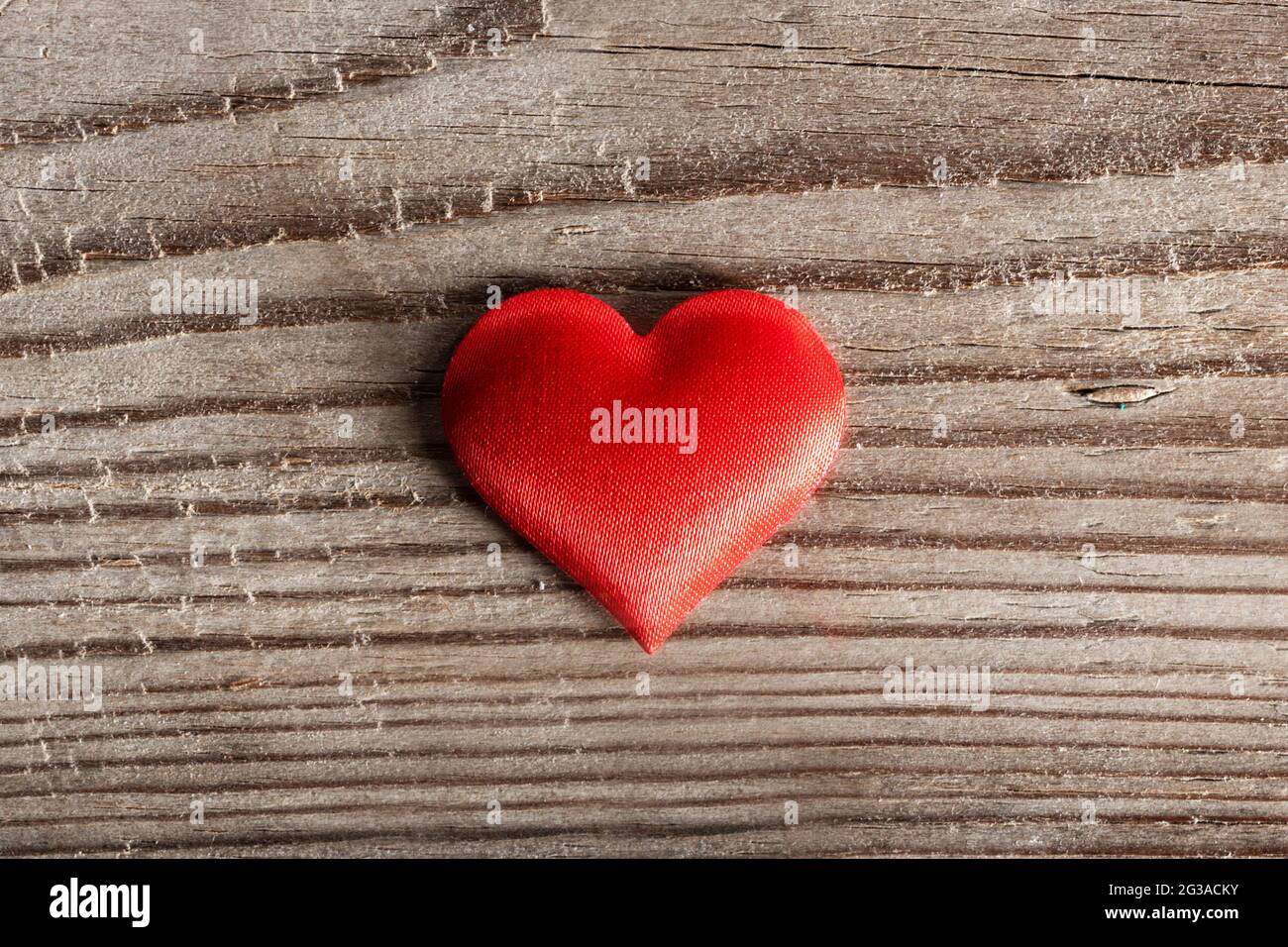 San Valentino cuore di seta rossa su sfondo di legno, concetto di amore Foto Stock