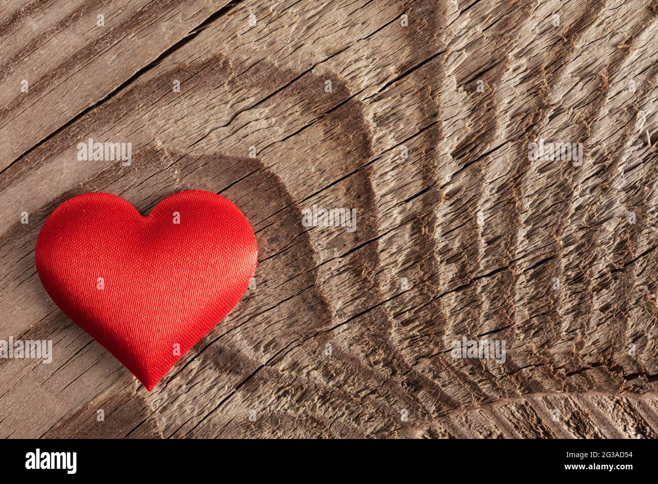 San Valentino cuore di seta rossa su sfondo di legno, concetto di amore Foto Stock