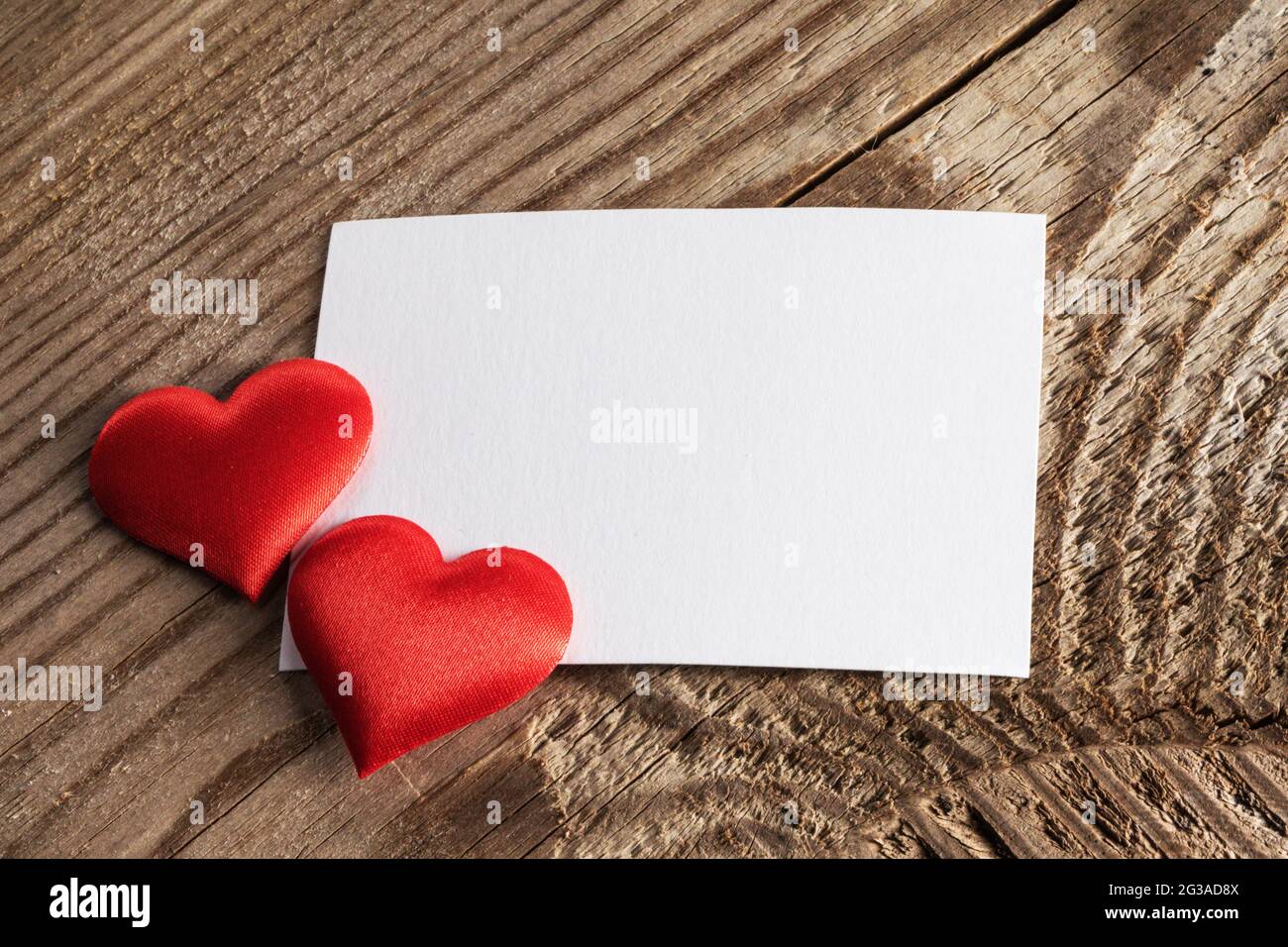 Giorno di San Valentino bianco carta bianco biglietto d'auguri e cuori di seta rossa, cornice di sfondo con spazio copia, concetto di amore Foto Stock