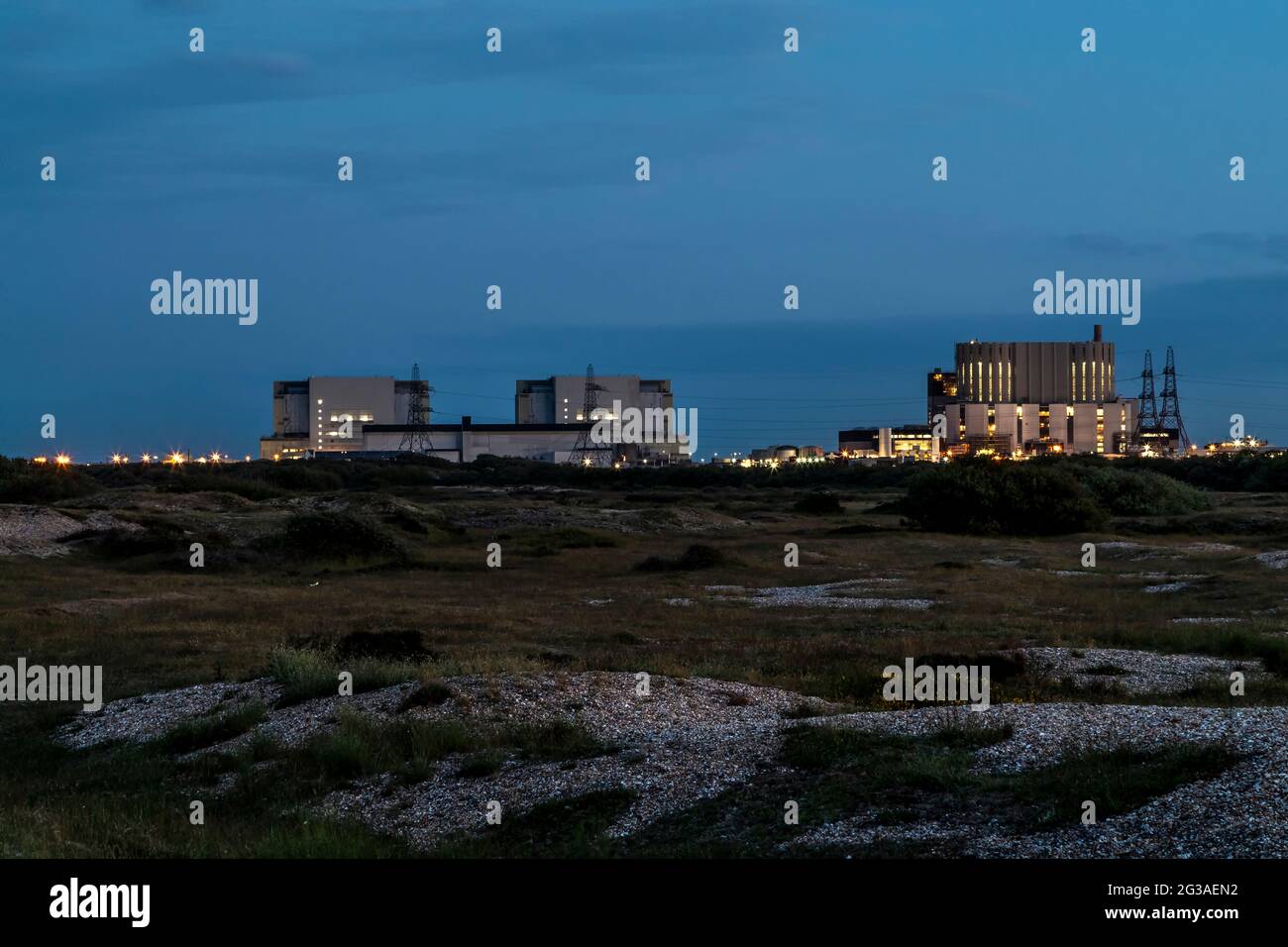 La centrale nucleare di Dungeness A & B è vista dall'altra parte dello shingle al crepuscolo, Dungeness, Romney Marsh, Kent, Engand, REGNO UNITO. Foto Stock