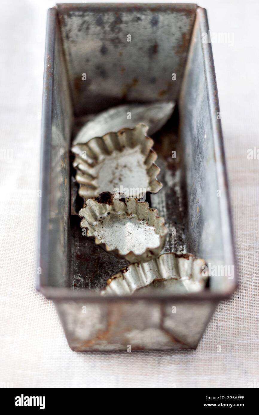 Vecchia teglia vintage e muffe da forno su sfondo bianco. Messa a fuoco selettiva. Foto Stock